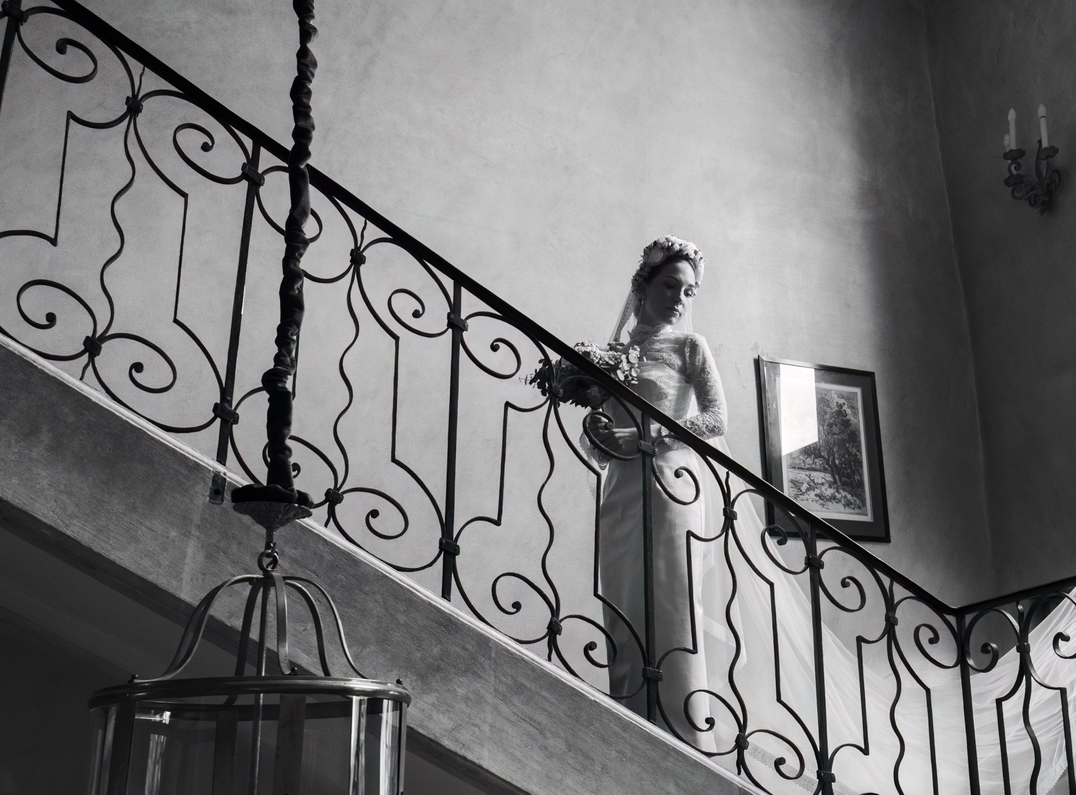 La mariée descend l'escalier en fer forgé, noir et blanc