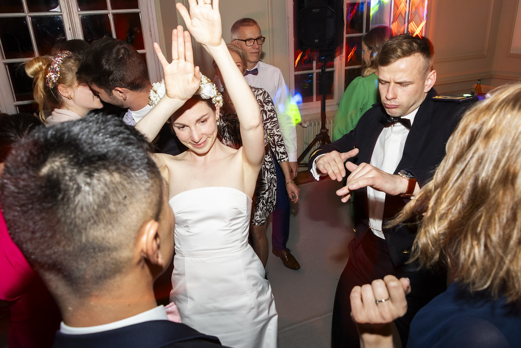 La mariée danse les bras levés au milieu de ses amis